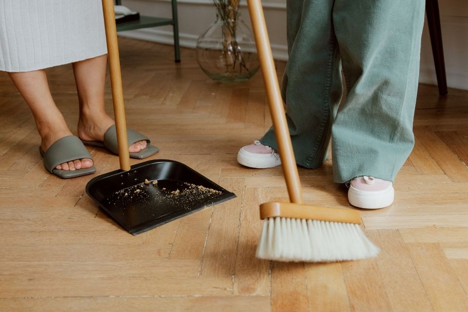 parent and child sweeping wood look flooring.